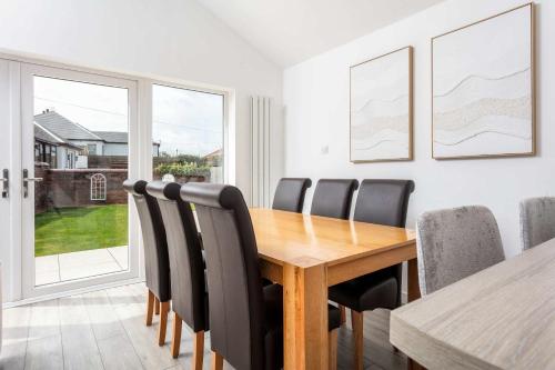 a dining room with a wooden table and black chairs at No20 Mansfield - Donnini Apartments in Prestwick