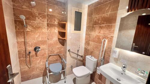 Un baño con ducha, inodoro y lavabo. en Al Khulfaa Al Masy - فندق الخلفاء الماسي, en Muzdalifah