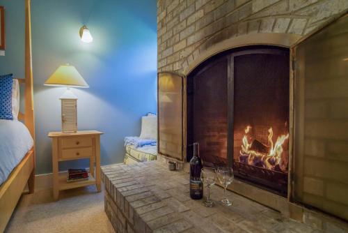 a room with a fireplace with a bottle of wine and glasses at The Edenwild Boutique Inn in Lopez