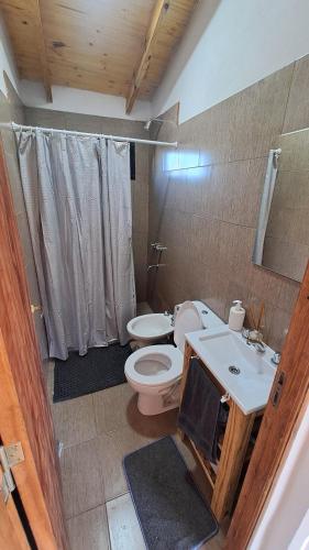 un baño con inodoro y lavabo en Entre Sierras y Sueños, en Villa Yacanto