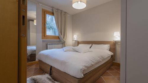 a bedroom with a bed with white sheets and a window at InstaView in Ponte di Legno