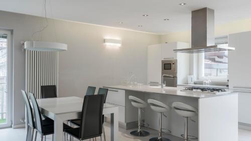 a white kitchen with a table and chairs at Snowhite in Incudine
