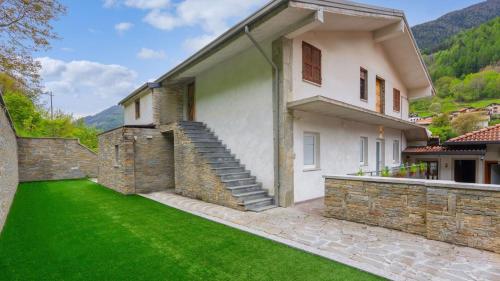 a house with a stone wall and a green lawn at Snowhite in Incudine