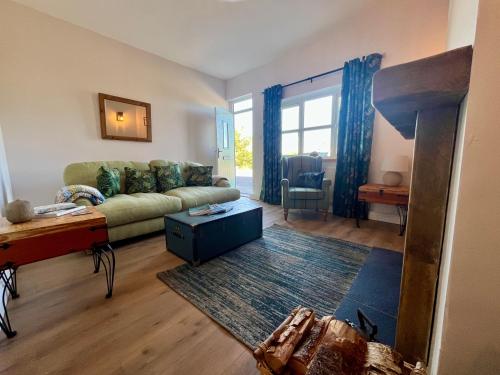 ein Wohnzimmer mit Sofa und Tisch in der Unterkunft Cosy cottage near Saltburn & Whitby in Boosbeck