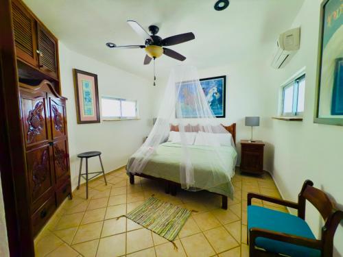 Un dormitorio con una cama con ventilador de techo. en UrbanEden 'Another Day In Paradise', en Playa del Carmen