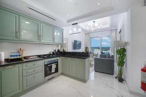 a kitchen with green cabinets and a view of the ocean at EasyGo- Luxury Living with Resort Facilities and Amenities in Dubai