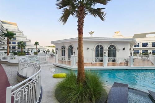 a resort with a palm tree and a swimming pool at EasyGo- Luxury Living with Resort Facilities and Amenities in Dubai