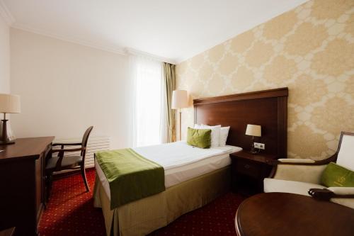 a hotel room with a bed and a desk at Hotel Splendor in Babice Nowe