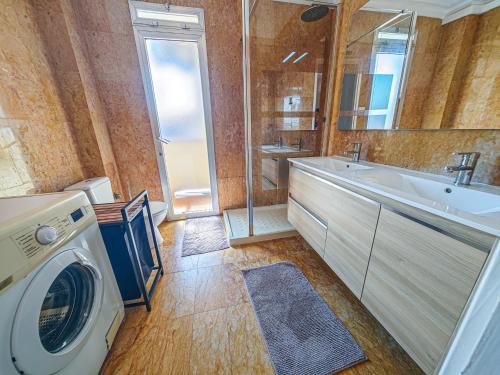 a bathroom with a washing machine and a sink at LITORAL COSTA DORADA - CORAL Only families in Cambrils