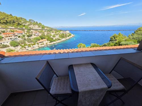 Un balcón con una silla y vista al agua. en Winery Bačić, en Blato