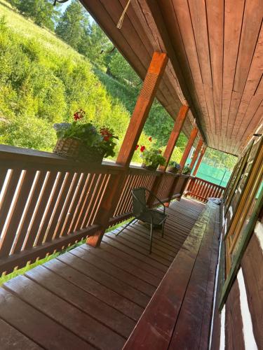 a wooden porch with potted plants and a bench at Chata SKI Jezersko in Jezersko