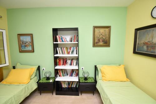 a room with two beds and a book shelf with books at Villa Meli in Sozopoli