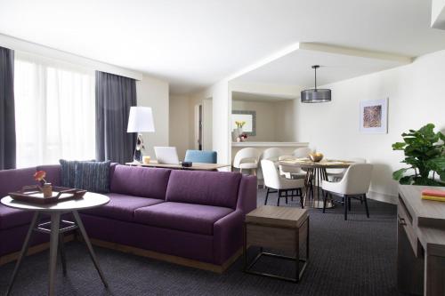 a living room with a purple couch and a dining room at Crowne Plaza Atlanta Perimeter at Ravinia by IHG in Atlanta