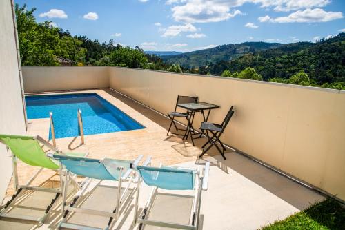a balcony with a table and chairs and a swimming pool at Casa do sol in Peitimão