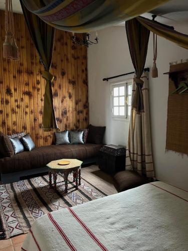 una sala de estar con un sofá y una mesa en Le Gîte Dayet Aoua, 