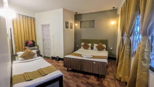 a room with two beds and a woman taking a picture at Hotel Sakura Mountain view Near Darjeeling Toy Train Station in Darjeeling