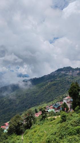 a view of a mountain with a town on a hill at Hotel Sakura Mountain view Near Darjeeling Toy Train Station in Darjeeling