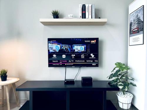 a black desk with a flat screen tv on a wall at Aurora Homes at i-City - WiFi TV Box and 1 Carpark in Shah Alam