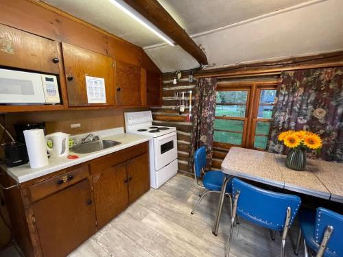 Una cocina con fregadero y una mesa con sillas. en Balsam Lake - 2-Bedroom Cottage #8, en Kawartha Lakes