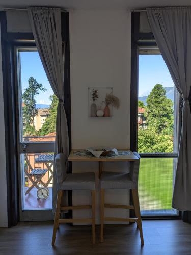 a table and a chair in front of a window at Lake & Montains View Studio with Free Parking, 1Hour from Stresa & Borromean Islands in Luino