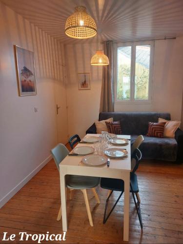 un salon avec une table avec des chaises et un canapé dans l'établissement Les Belles Terrasses Dieppe ,3 appartements , LE VEGETAL de 1 à 8 personnes , LE TROPICAL de 1 à 6 personnes , LE FLORAL avec TERRASSE de 1 à 3 personnes , quartier calme au stationnement gratuit à coté de l'avenue verte, à Dieppe