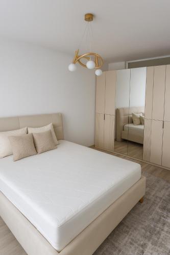 a white bedroom with a large bed and a couch at La Vue in Vitina