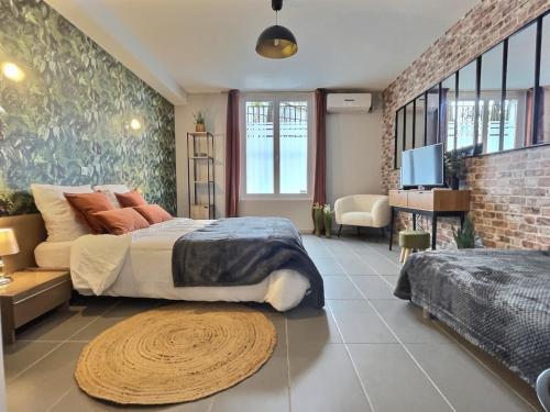 a bedroom with a large bed and a living room at Le Carnot in Valence