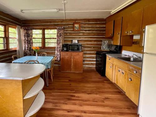 a kitchen with wooden cabinets and a table with a tableablish at Balsam Lake - 2-Bedroom Cabin in Kawartha #11 in Kawartha Lakes