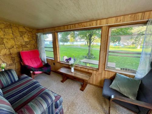 Una sala de estar con un sofá y sillas y una ventana. en Balsam Lake - 3-Bedroom Cottage #3, en Kawartha Lakes