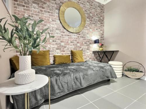 a bedroom with a bed and a brick wall at Le Carnot in Valence