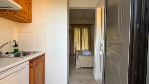 a kitchen with a sink and a door to a hallway at Ionian Sunset in Lefkada