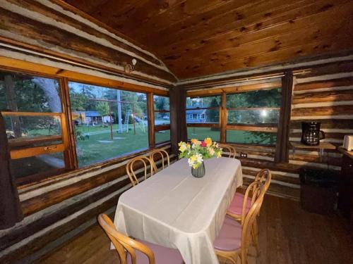 Un comedor con una mesa con un jarrón de flores encima. en 3-Bedroom Cottage #7 - Balsam Lake, en Kawartha Lakes