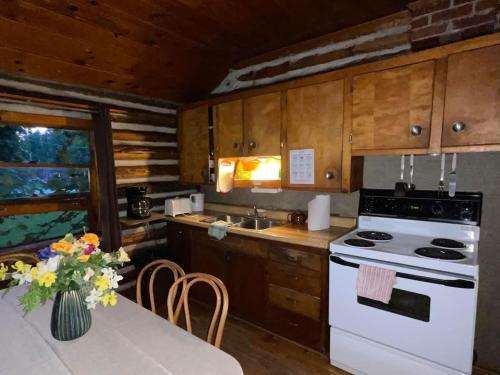 cocina con fogones blancos y mesa en 3-Bedroom Cottage #7 - Balsam Lake, en Kawartha Lakes