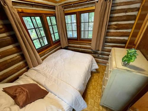 a bedroom with two beds in a log cabin at 2-Bedroom - Balsam Lake Cottages Resort #12 in Kawartha Lakes