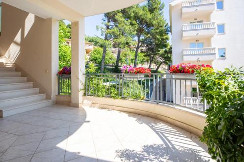 a balcony of a apartment building with flowers at Villa Alesa Steva in Tučepi