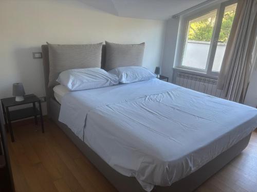 - une chambre dotée d'un grand lit avec des draps blancs et une fenêtre dans l'établissement La Magnolia B&B, à Montesilvano
