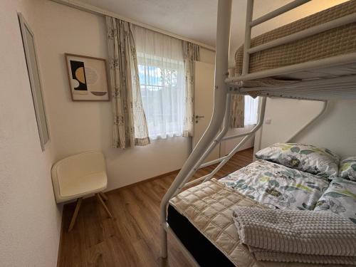 a bedroom with a bunk bed and a chair at Landhaus HALLSTATT FEELING - Apartment - Self Check-in in Bad Goisern