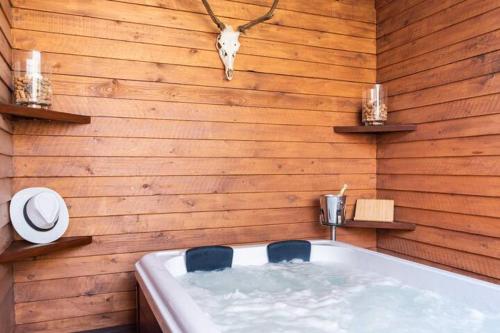 Una bañera con dos sillas en una pared de madera. en Angels Cabin, en San Bartolomé