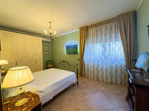 a bedroom with a bed and a lamp and a window at Relais Casale Corvo in Guglionesi