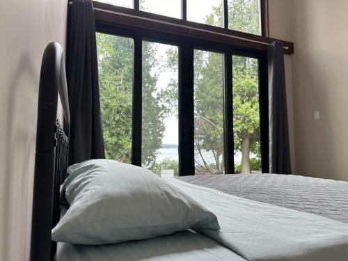 a bed with a pillow in front of a window at 3-bedroom Lakefront Villa #9 in Lakefield