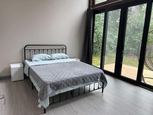 a bedroom with a bed and a large window at 3-bedroom Lakefront Villa #9 in Lakefield