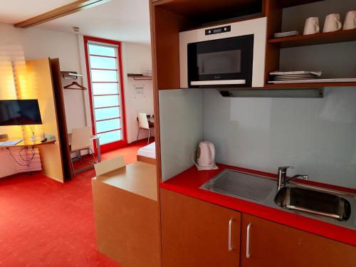 a kitchen with a sink and a microwave at Orange Wings Wiener Neustadt in Wiener Neustadt