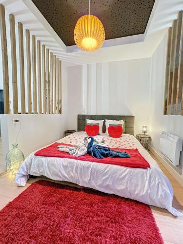 - une chambre avec un grand lit et un tapis rouge dans l'établissement Love Room avec jacuzzi & lit King Size, à Saint Etienne