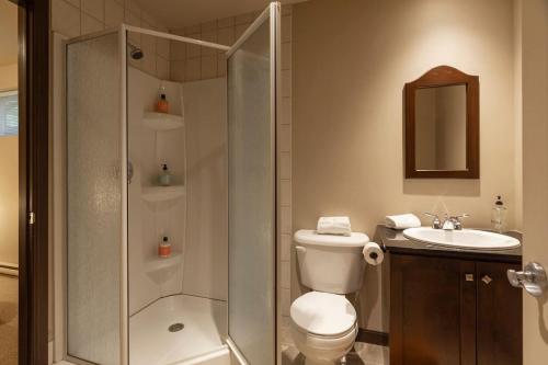 a bathroom with a shower and a toilet and a sink at Piscine - Golf - Velo INOUT - Espace Jeux - Navette in Mont-Tremblant