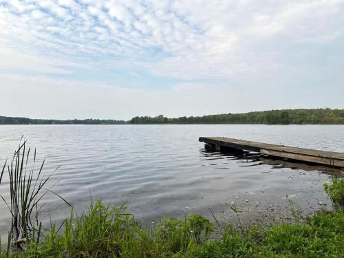 a dock on a lake with trees in the background at 3-bedroom Lakefront Villa #5 in Lakefield