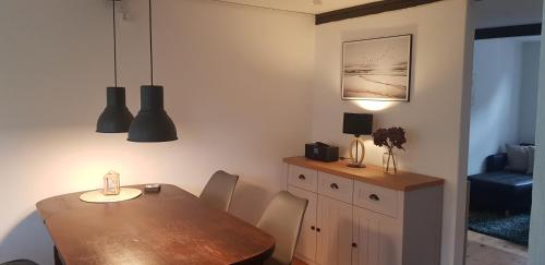 a dining room with a wooden table and a table and chairs at Fischerstern in Maasholm