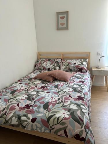 a bedroom with a bed with a floral comforter at La Casa del Borgo in Rieti