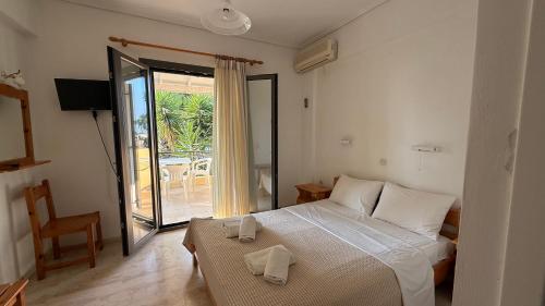 a bedroom with a bed and a sliding glass door at Ionian Sunset in Lefkada