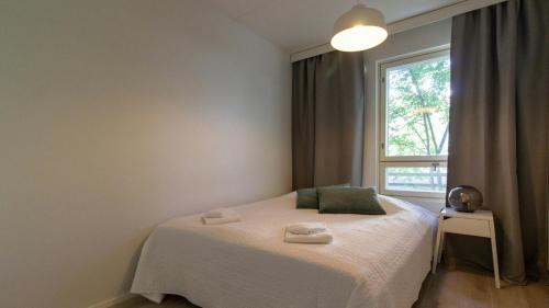 a bedroom with a white bed with a window at Spacious Apartment for 4 in Vantaa
