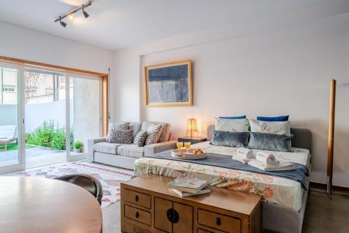 a bedroom with a bed and a couch and a table at HostWise – Modern Flat w/ Terrace | Near the Beach in Matosinhos